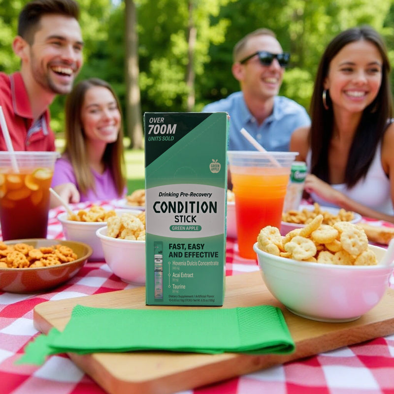 Box of 'Condition Stick' on a picnic table with people in the background